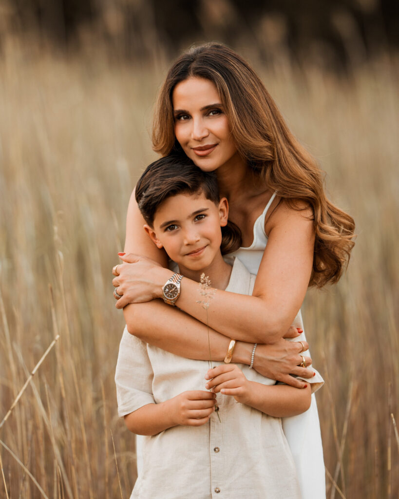 Mama umarmt ihren Sohn von hinten im hohen Gras, Kinder und Mommy and Me Shooting Hannover